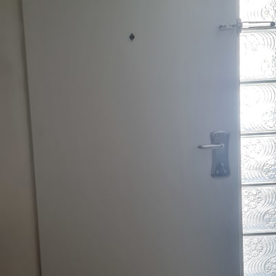 דלת עם ידית מתכת ליד חלון זכוכית מעוצב