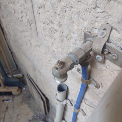 ברז מים מחובר לקיר עם צינור כחול