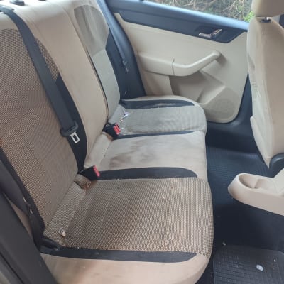 מושב אחורי מלוכלך ברכב עם כתמים ולכלוך