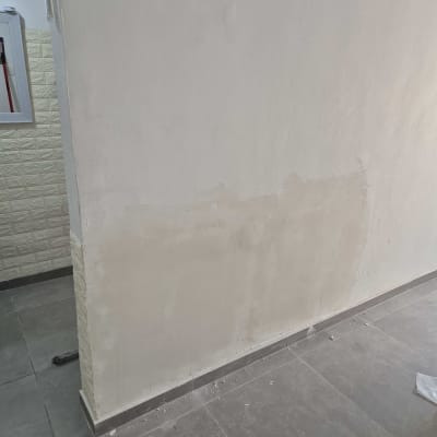 עבודת החלקה ותיקון שפכטל בחלק התחתון של קיר פנימי בדירה