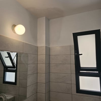 קיר צבוע בלבן עם תאורה עליונה