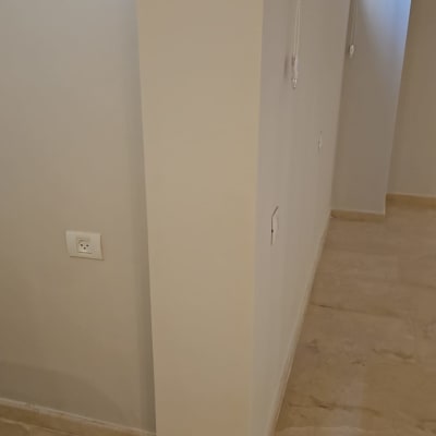 קיר צבוע בצבע בהיר עם שקע חשמל