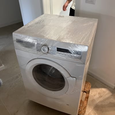 מכונת כביסה עטופה בניילון על עגלת הובלה