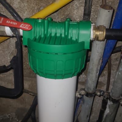 מסנן מים ירוק ולבן עם צינורות מחוברים