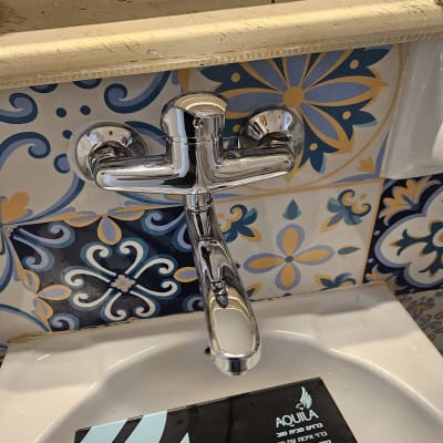 ברז כרום מעל כיור עם אריחים מעוצבים