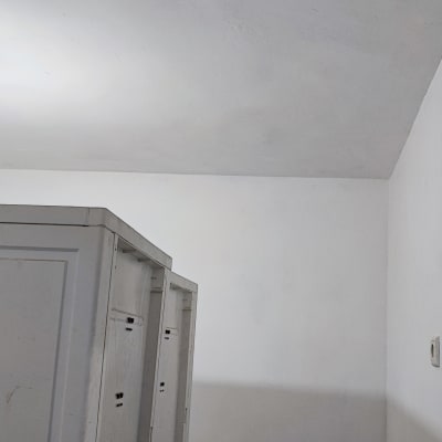 מנורה תלויה מהתקרה בחדר עם קירות לבנים