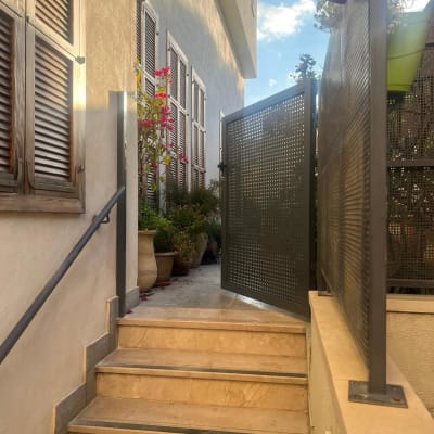 שער מתכת פתוח ליד מדרגות אבן