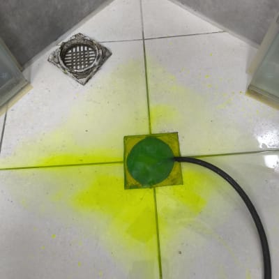 נוזל צהוב על רצפת מקלחת עם ניקוז