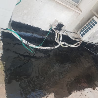 איטום גג בזפת שחורה ליד מזגנים וצינורות