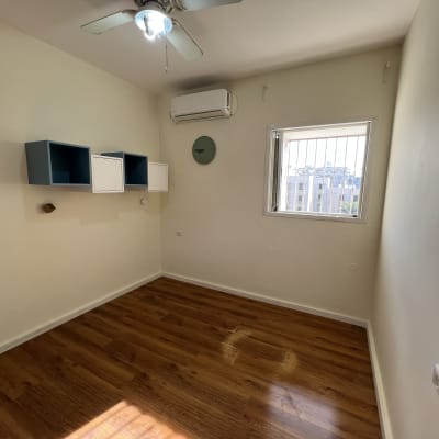 חדר עם קירות צבועים בלבן ורצפת עץ