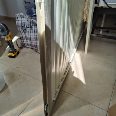 תריס מתכת עומד על רצפה, עם גלגלים קטנים בתחתית.