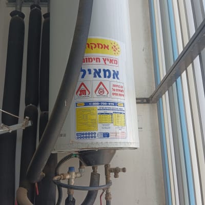 דוד שמש עם צינורות ומדבקות אזהרה