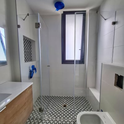 מקלחון זכוכית עם רצפת אריחים מעוצבת