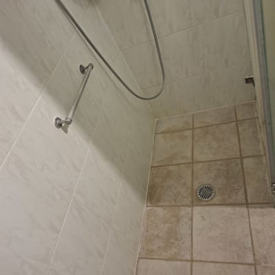 מקלחת עם אריחים ומקלחת יד