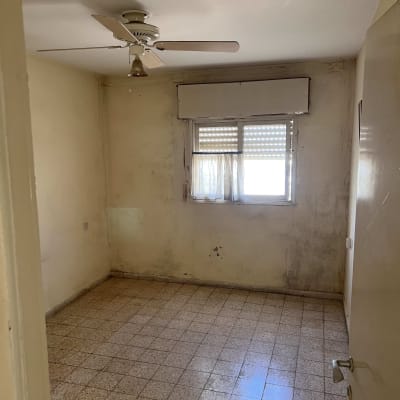 חדר ריק עם מאוורר תקרה וחלון