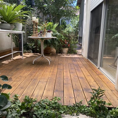 דק עץ עם צמחים ועציצים על שולחנות