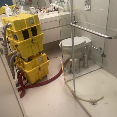 מכונת ייבוש צהובה בחדר אמבטיה עם מקלחת ושירותים