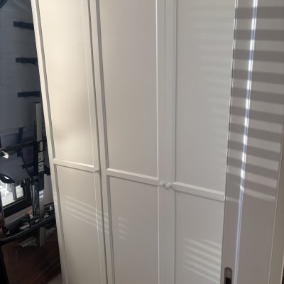 ארון לבן עם דלתות סגורות בחדר מואר.