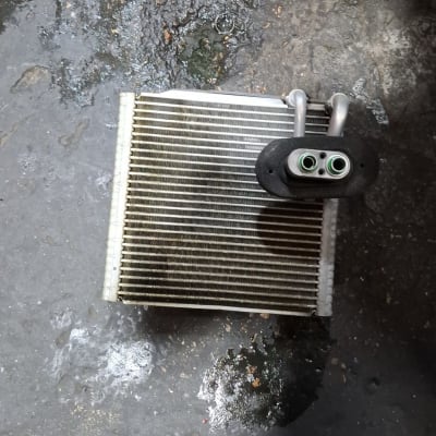 רדיאטור קטן עם צינורות על רצפה מלוכלכת