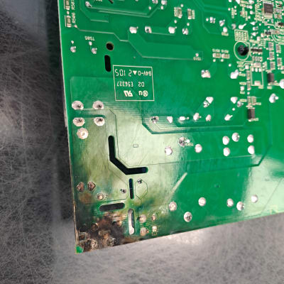 מעגל מודפס ירוק עם סימני שריפה בפינה התחתונה