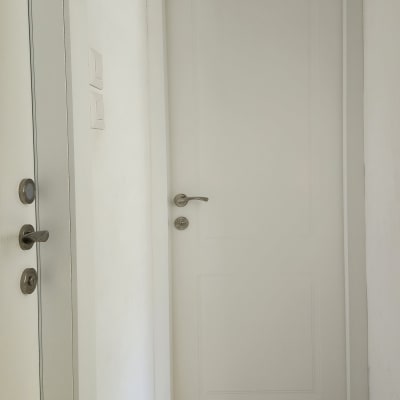 דלת לבנה עם ידית מתכת בחדר פנימי