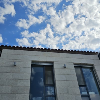 שני חלונות זכוכית בקיר אבן עם שמיים מעוננים