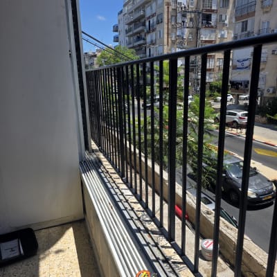 מרפסת עם מעקה מתכת וכלי עבודה