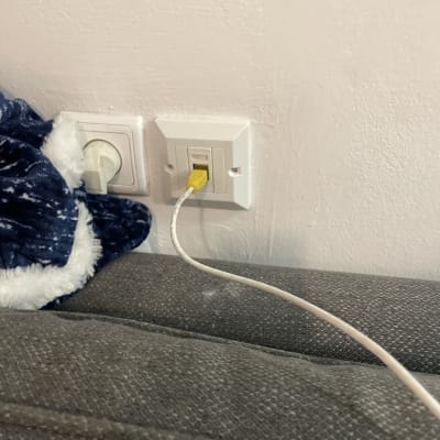 שקע רשת עם כבל צהוב מחובר לקיר