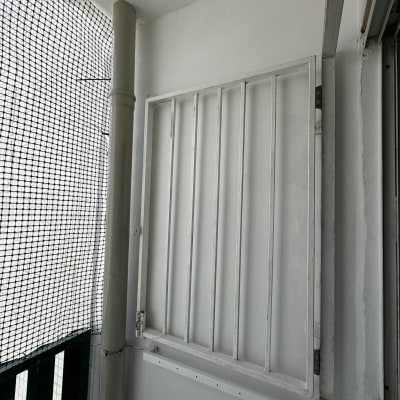 סורג מתכת לבן מותקן על קיר חיצוני