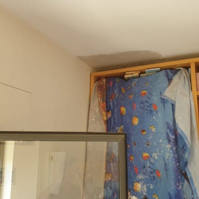 סולם צבוע ליד קיר עם תיקון טיח