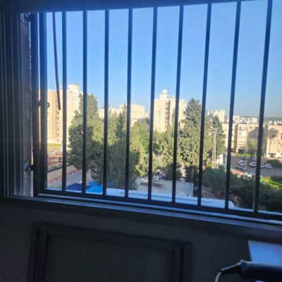 סורגים על חלון עם נוף עירוני ברקע