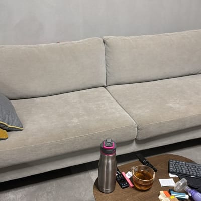 ספה אפורה עם כריות, מוצרי ניקוי בצד