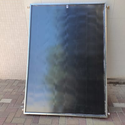 קולט שמש שחור עם מסגרת מתכת על רצפה מרוצפת