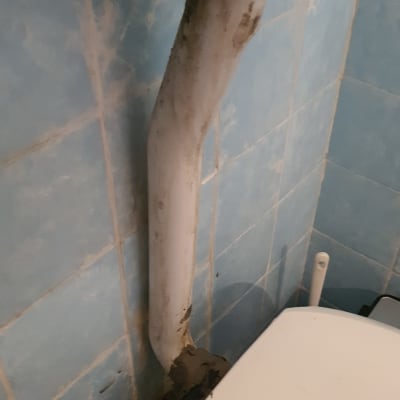 צינור ביוב מתחת לכיור עם כתמי חלודה