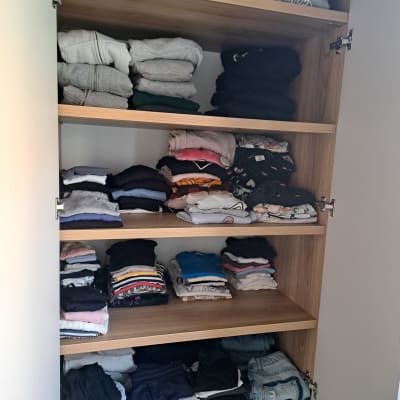 ארון בגדים מסודר עם בגדים מקופלים על מדפים