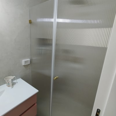 מקלחון זכוכית בחדר אמבטיה עם כיור