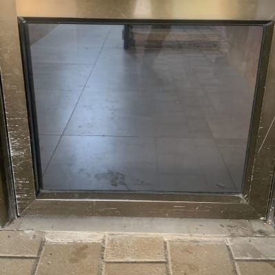 דלת זכוכית עם מסגרת מתכתית ושריטות קלות