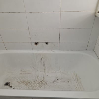 אמבטיה מלוכלכת עם אריחים לבנים