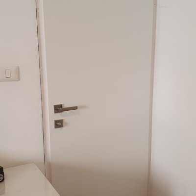 דלת לבנה עם ידית מתכת כסופה