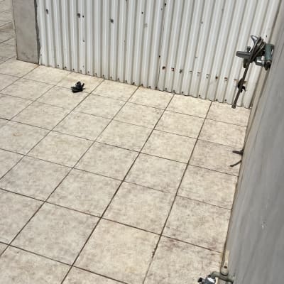 רצפה מרוצפת עם ברז וקיר מתכת