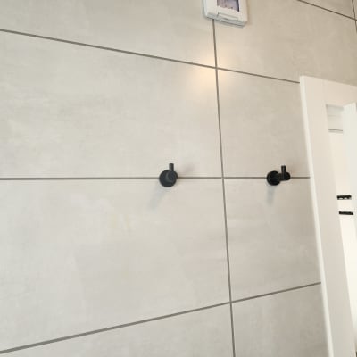 שני ווים שחורים מותקנים על קיר אריחים