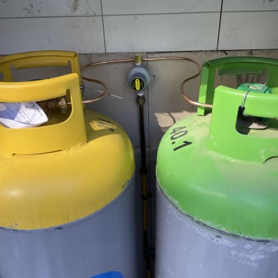 שני בלוני גז צהוב וירוק עם צינורות ומד לחץ