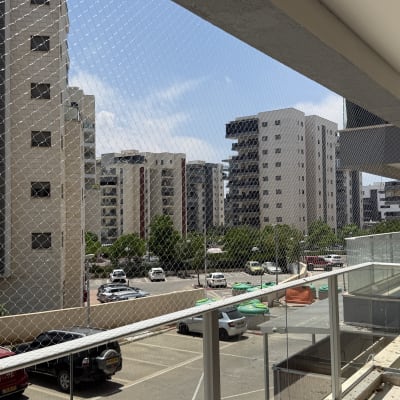 מרפסת עם רשת הגנה נגד יונים בבניין מגורים