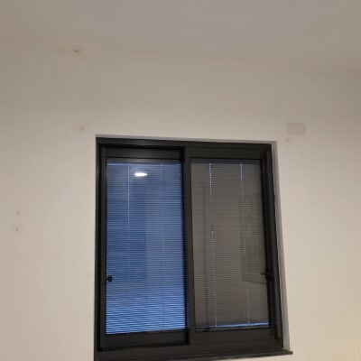 חלון עם תריסים שולחן קטן עם חפצים שונים