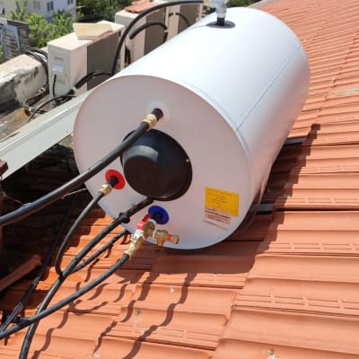 דוד שמש לבן על גג רעפים עם צינורות מחוברים