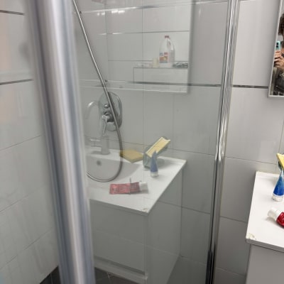 מקלחת עם כיור ומוצרים לניקוי