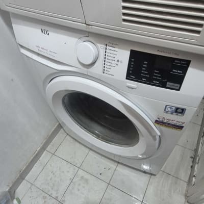 מכונת כביסה AEG בחדר כביסה עם רצפה רטובה