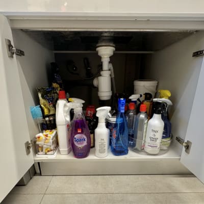 מוצרי ניקוי מאורגנים בארון מתחת לכיור