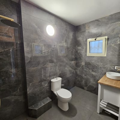 חדר אמבטיה משופץ עם קירות אריחים אפורים