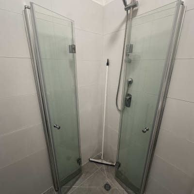 מקלחת עם דלתות זכוכית ומקלחת יד